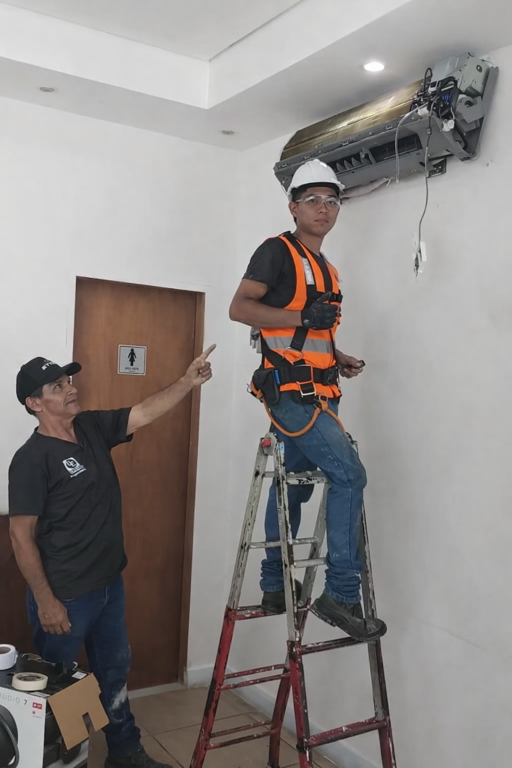 Equipe em manutenção de ar condicionado